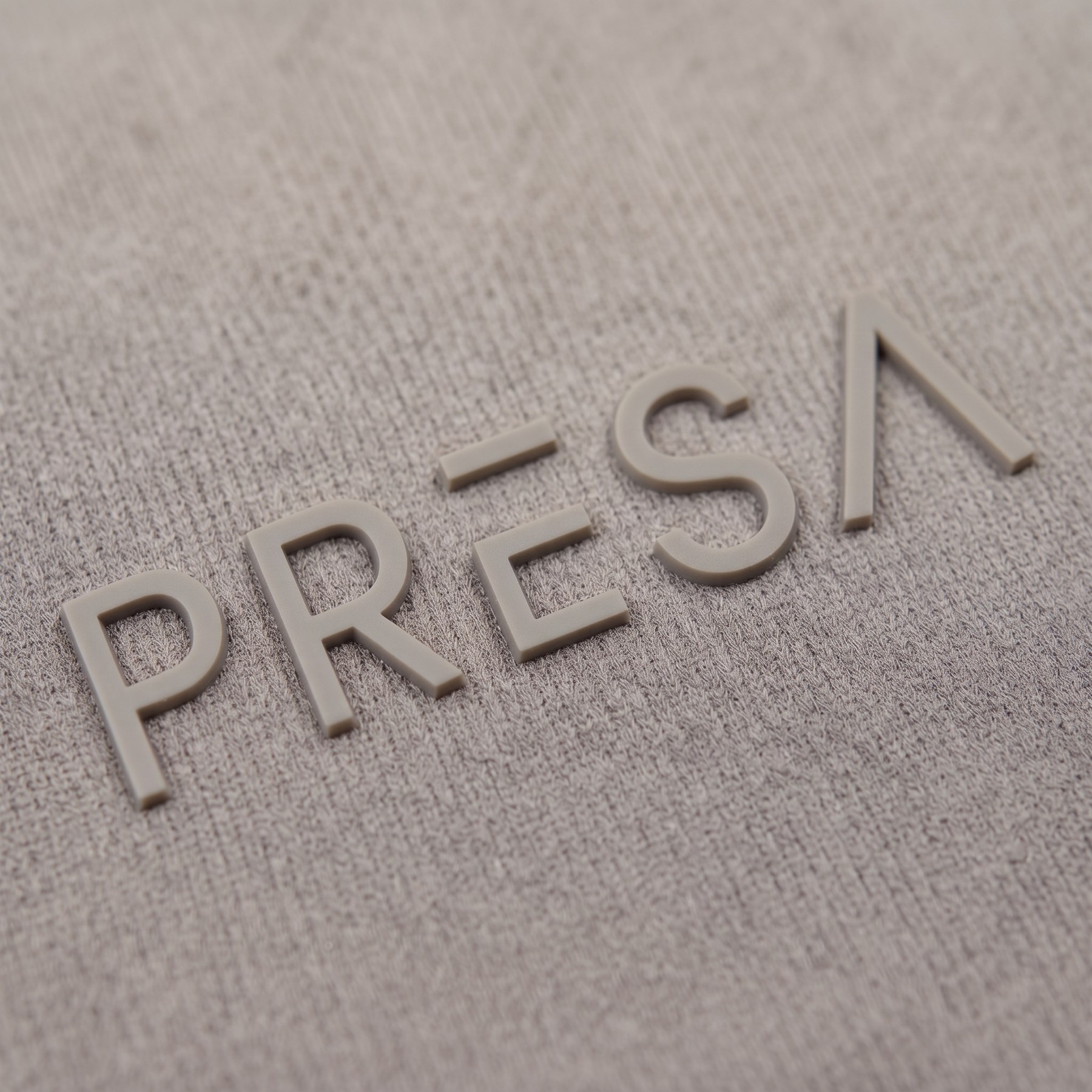 PRESA raised logo detail, stone